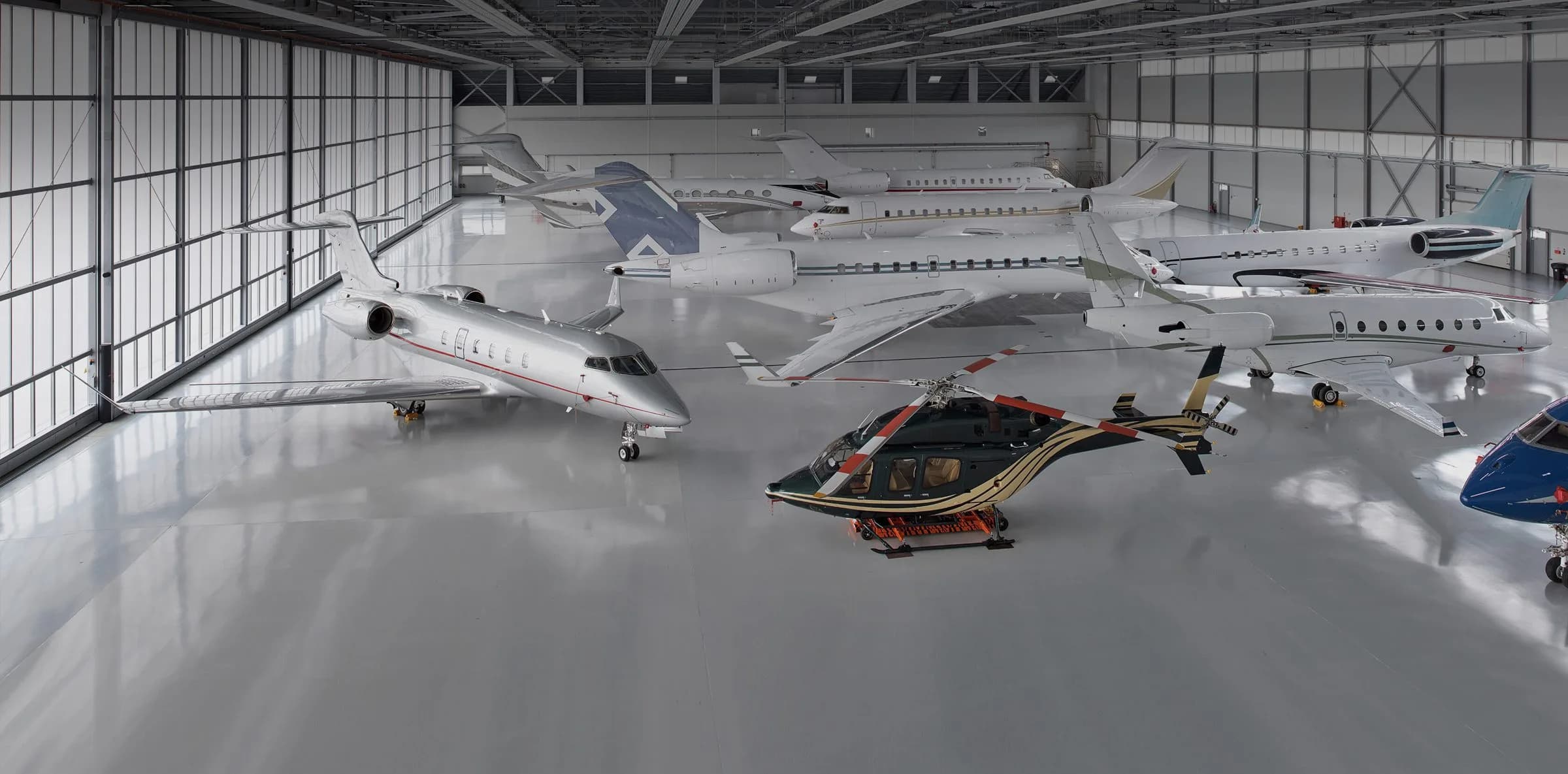 Business jets and a helicopter in the FBO RIGA hangar